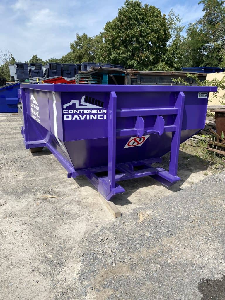 Purple Conteneur Davinci dumpster container outdoors on gravel ground with trees and other containers in the background